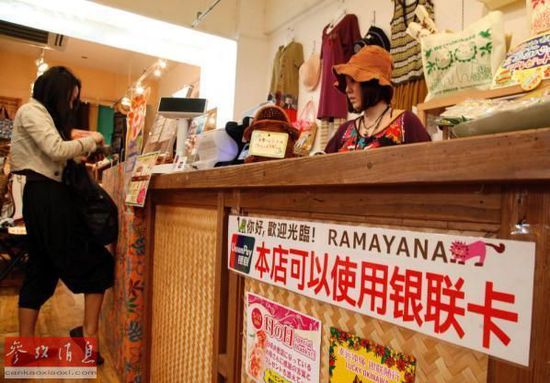 日本冲绳一家商场为吸引中国游客购物，贴出可以使用银联卡消费的标识